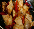 A pan filled with succulent meat and vibrant peppers, showcasing the essence of Indian and Nepali cuisine.