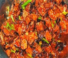 A colorful bowl filled with meat and vegetables in a pan, representing the best of Indian and Nepali culinary offerings.
